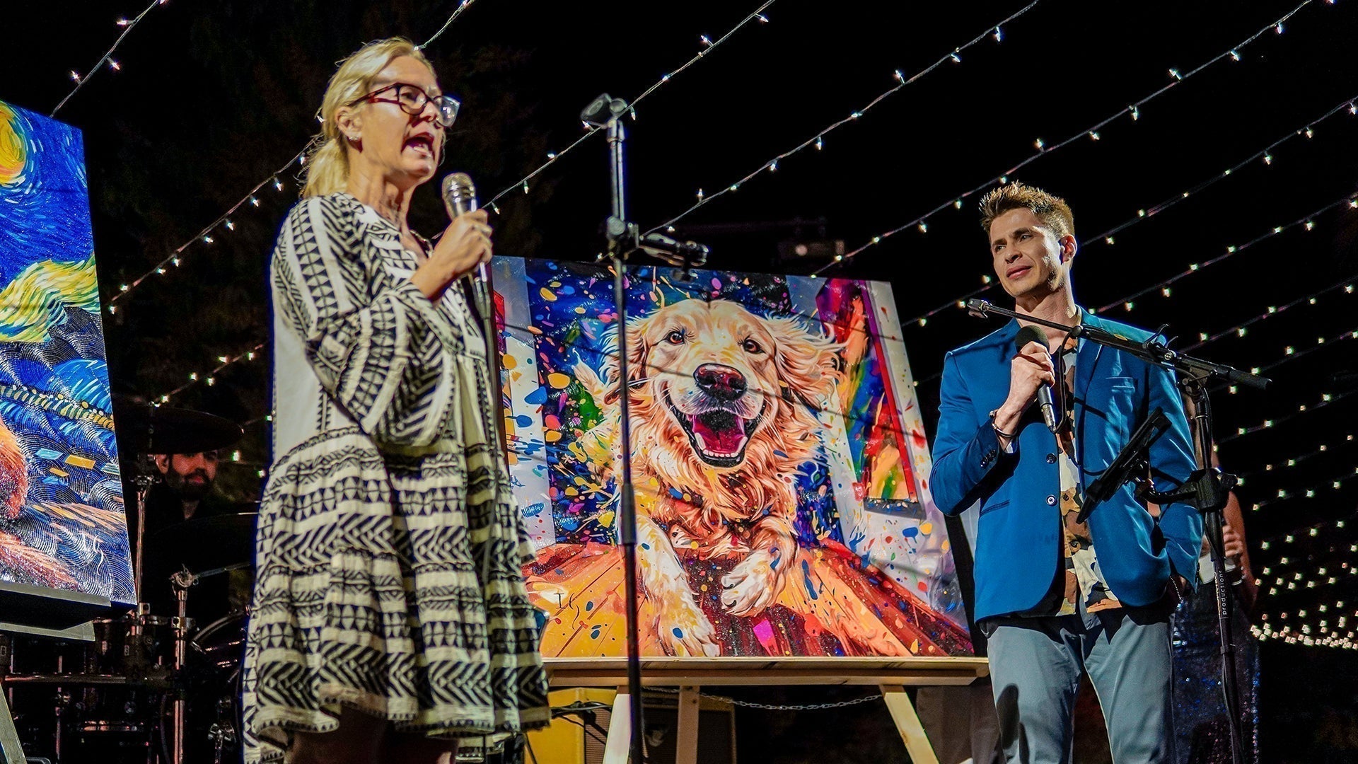 Ivan Guaderrama presenting a colorful dog painting at Baja S.A.F.E.'s Under the Stars fundraiser to support rescued animals in Los Cabos.