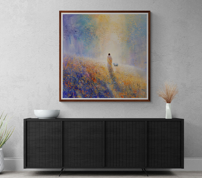 Framed artwork of Jesus walking with a sheep towards light, displayed above a modern console table.